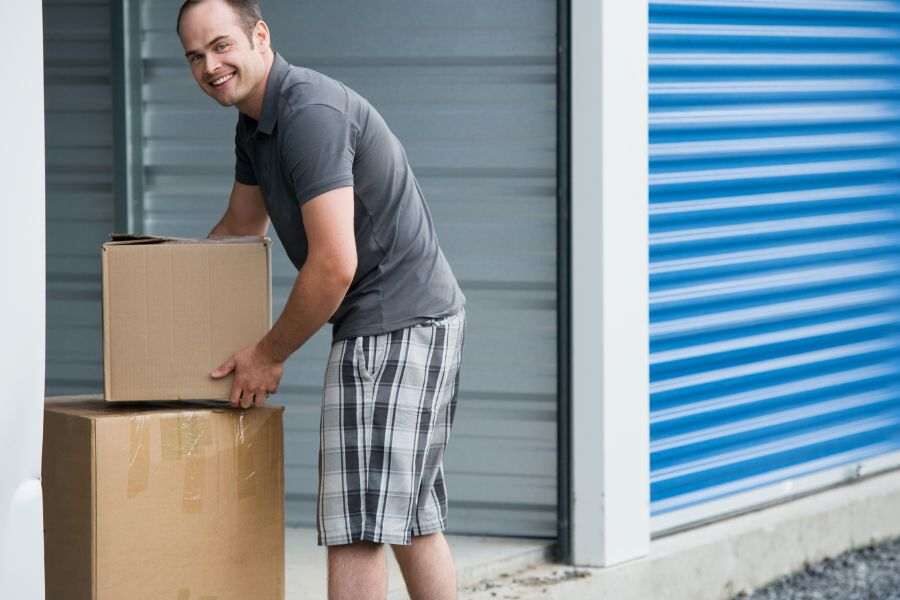 man loading a storage unit with boxes