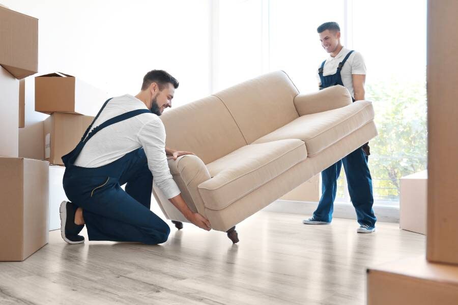two men preparing a couch for storage